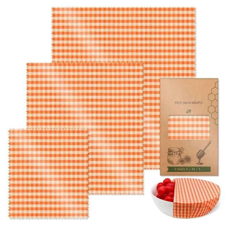 3-piece set of reusable beeswax food wraps with orange checkered pattern and eco-friendly packaging