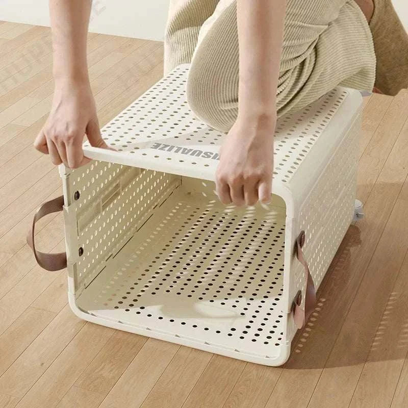 Foldable laundry organizer basket with handles and ventilation holes on wooden floor