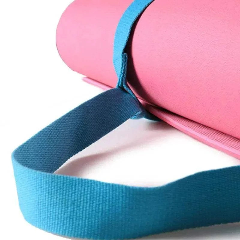 Adjustable blue yoga mat carry belt strap holding a pink yoga mat