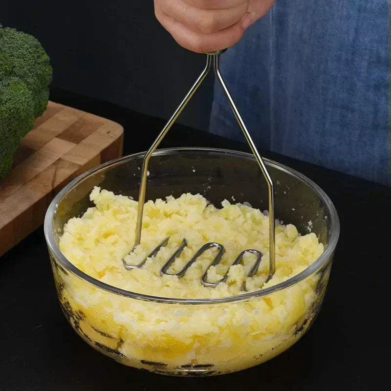 Stainless steel potato masher with ergonomic non-slip handle and rounded wire head for smooth mashing and cookware protection