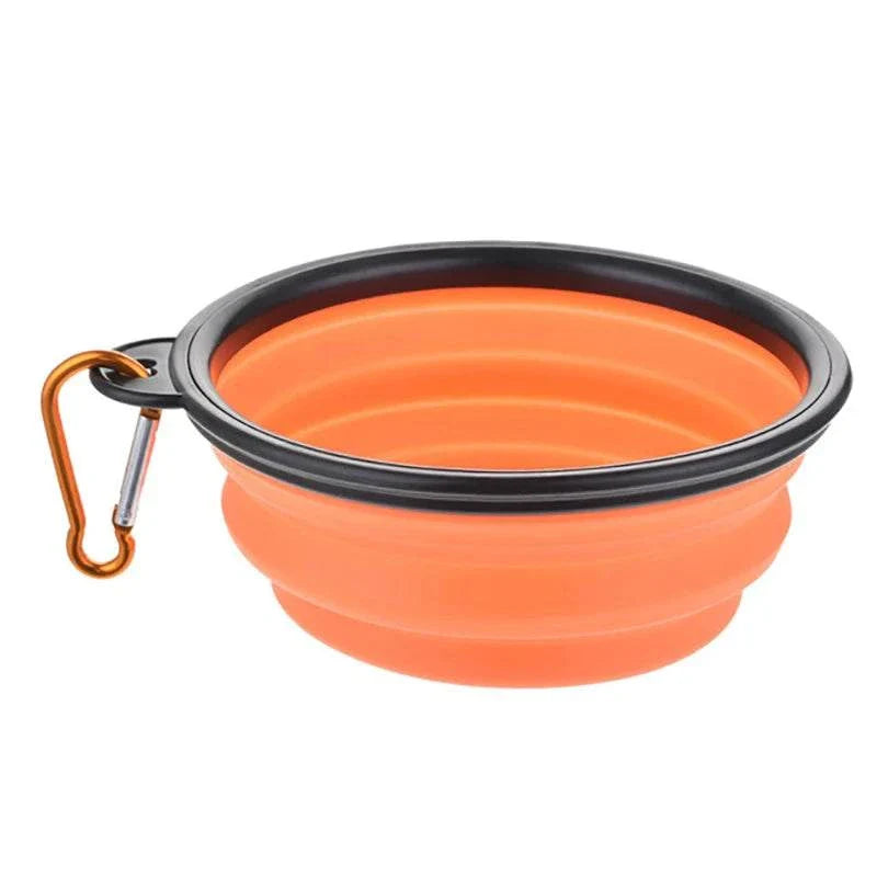 Collapsible orange silicone pet dog bowl with black rim and carabiner clip for travel and outdoor use