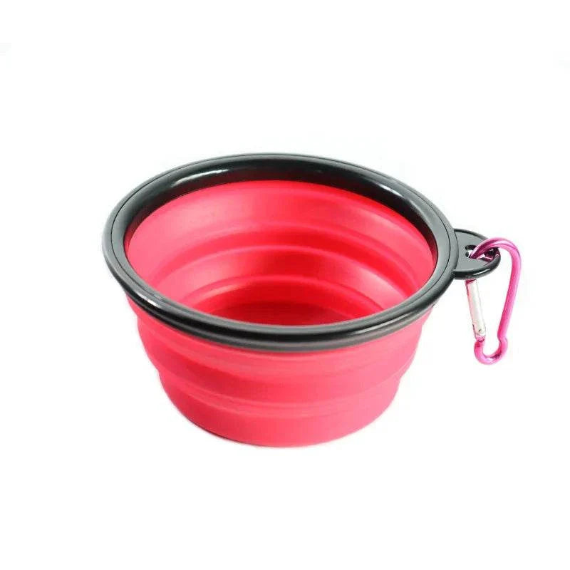 Collapsible red pet dog bowl with black rim and carabiner clip for portable outdoor use