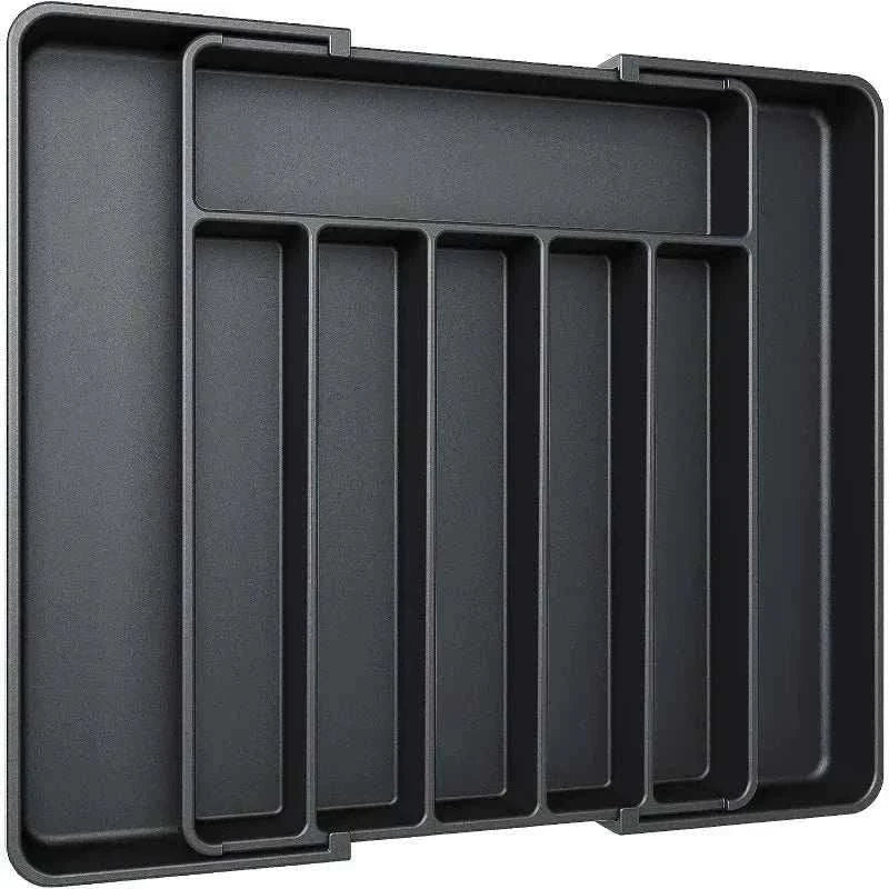 Adjustable black plastic pantry organizer tray with multiple compartments for kitchen utensils and silverware.