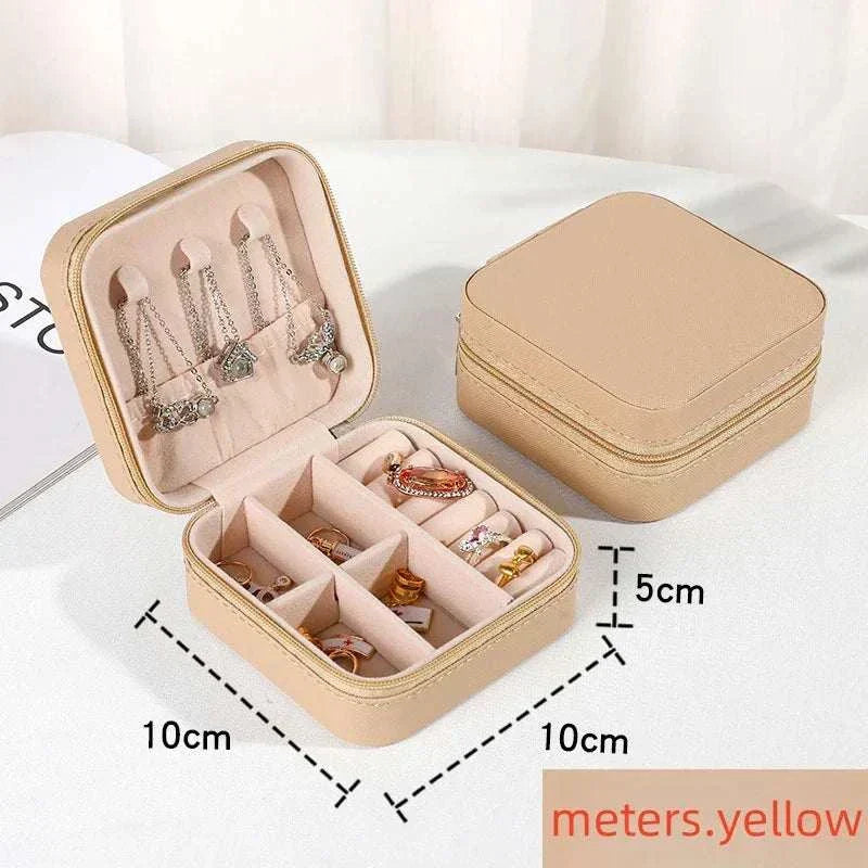 Compact beige mini jewelry box with PU leather exterior, divided compartments for rings and earrings, portable travel case