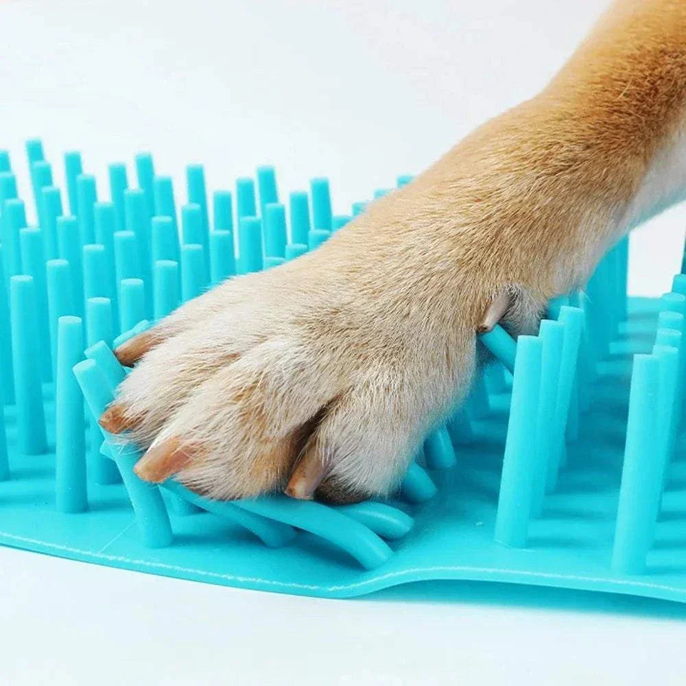 Dog paw on blue silicone pet paw cleaner brush mat for foot cleaning
